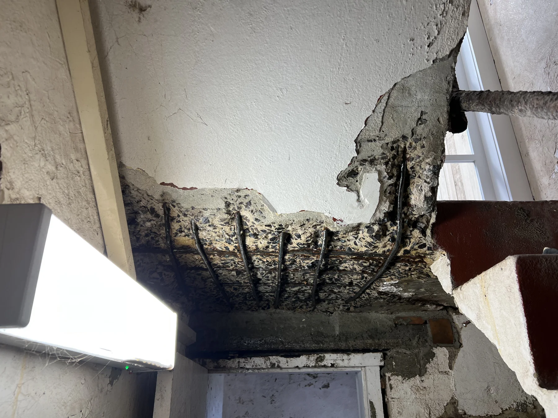 Exposed reinforcement beneath a concrete stair landing
